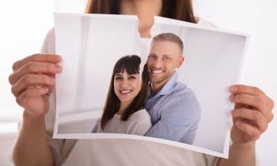 Woman's hand tearing photograph of ex